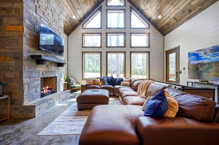 Leather sectional with a blue knit throw and pillows beside a window