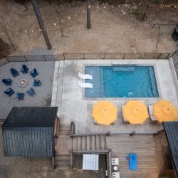Aerial view of the pool with two white in-pool loungers and a yellow umbrella