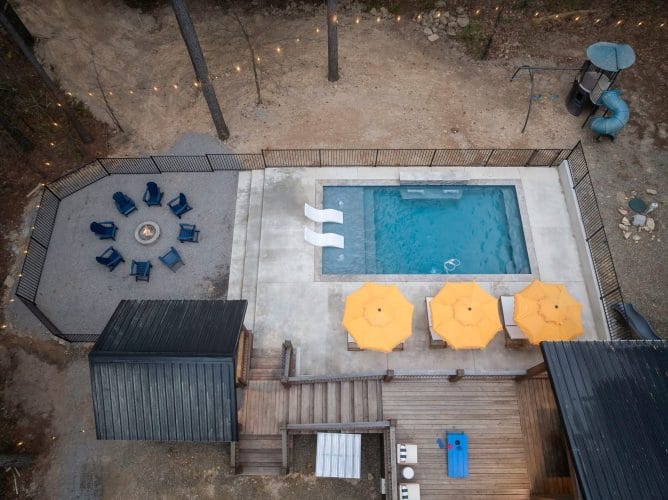Aerial view of the pool with two white in-pool loungers and a yellow umbrella