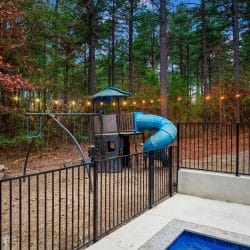 Kids playset with a blue spiral slide under string lights