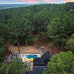 Aerial view of the treeline with string lights and a small table