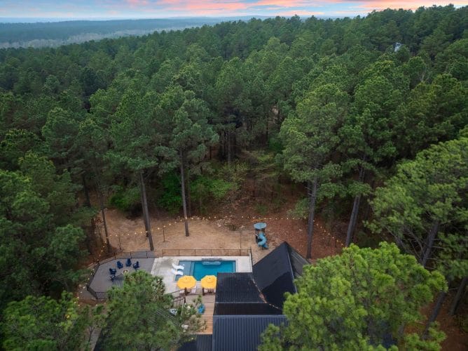 Aerial view of the treeline with string lights and a small table
