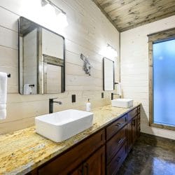 Double vanity with two vessel sinks, granite counter and black faucets