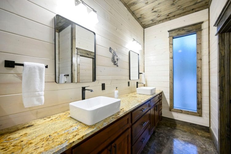 Double vanity with two vessel sinks, granite counter and black faucets