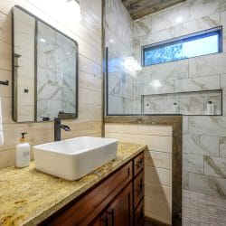 Vessel sink and mirror beside a glass shower