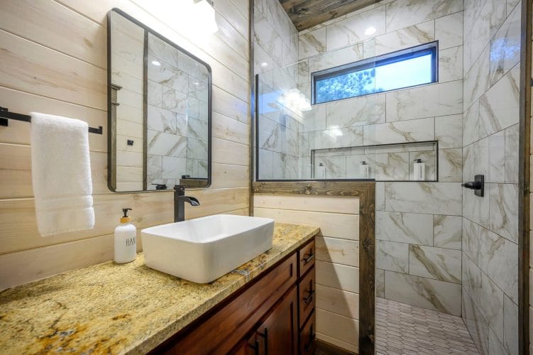 Vessel sink and mirror beside a glass shower