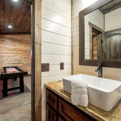 Corner of a bathroom with a wood-framed mirror and light switches above a sink