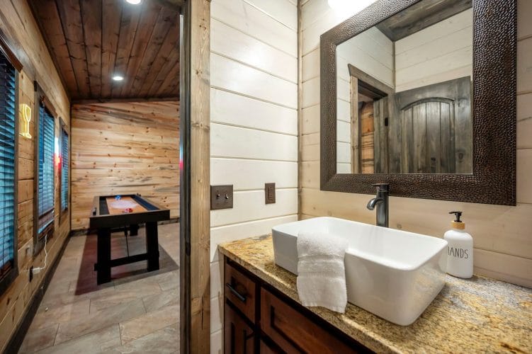 Corner of a bathroom with a wood-framed mirror and light switches above a sink