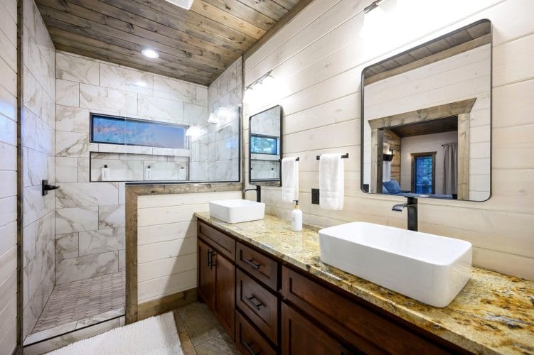 Vessel sink with a window into the shower and hanging white towels