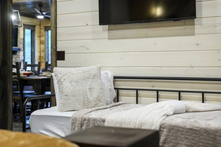 Close view of a fluffy pillow against a black metal daybed frame