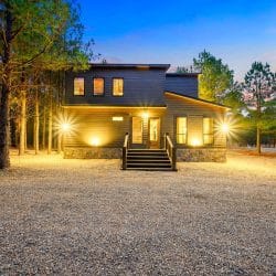 Front steps with lights at dusk and a stone foundation