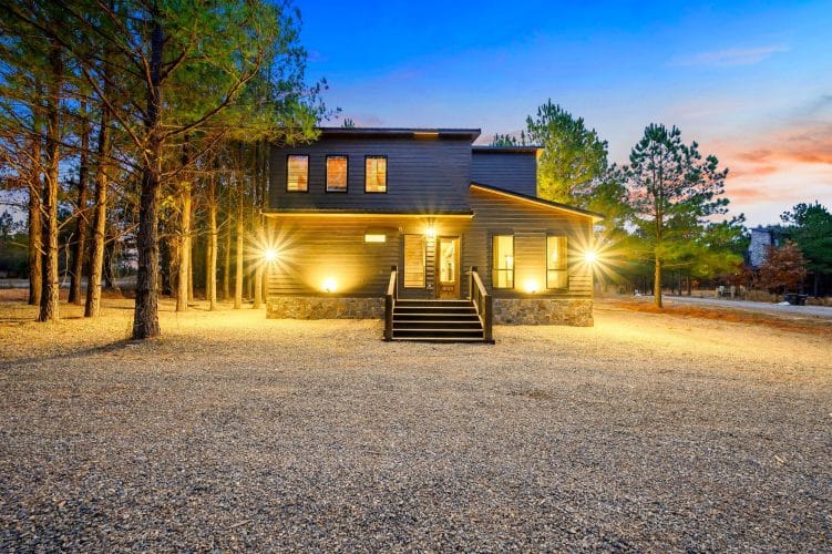 Front steps with lights at dusk and a stone foundation
