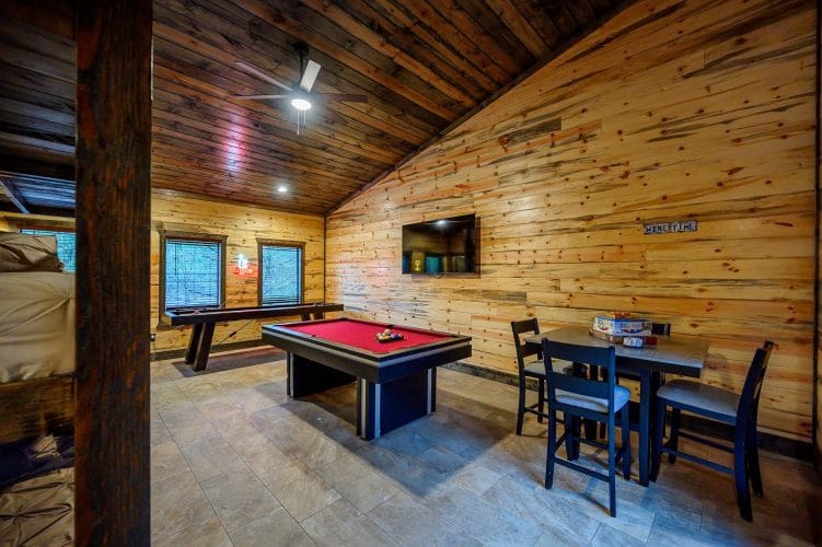 Pool table, a wall-mounted TV and a corner table in the bunk room game area
