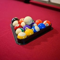 Billiard balls racked on red pool table felt