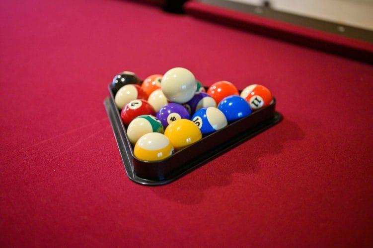 Billiard balls racked on red pool table felt