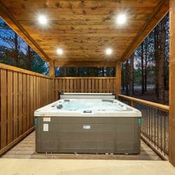 Hot tub with its cover rolled back behind a wooden privacy screen