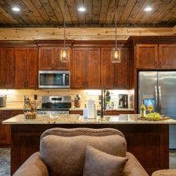 Stainless range and microwave with wood cabinets, granite counter and a coffee maker