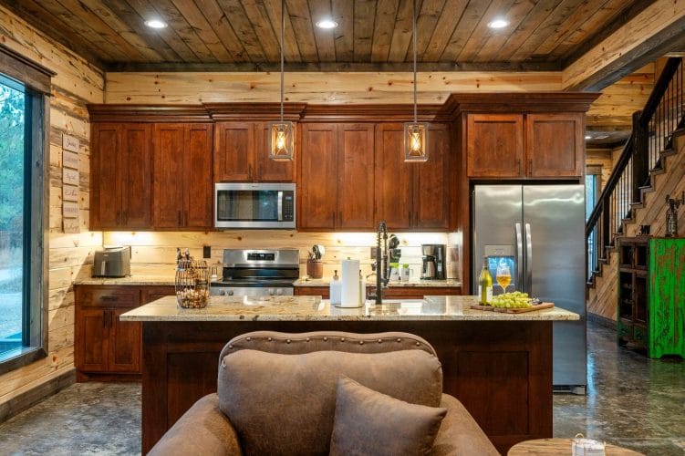 Stainless range and microwave with wood cabinets, granite counter and a coffee maker
