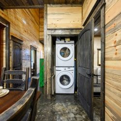 Stacked washer and dryer in a closet with a green-painted door