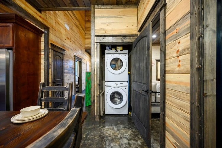 Stacked washer and dryer in a closet with a green-painted door