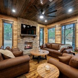 Brick fireplace with gas logs, TV above the mantel and a brown leather couch