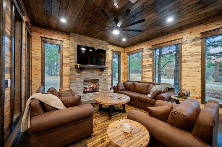 Brick fireplace with gas logs, TV above the mantel and a brown leather couch