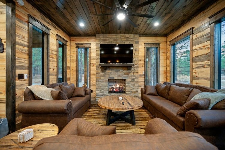 Fireplace with a TV over the wood mantel and a round wood coffee table