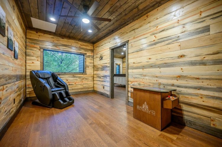 Open loft with hardwood floors and a doorway to a bedroom with a white headboard