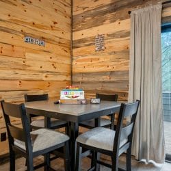 Stack of board games on a gray table in front of a wood wall