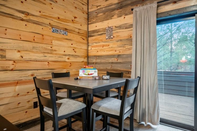 Stack of board games on a gray table in front of a wood wall