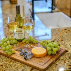 Wine glass and green grapes on a wooden board