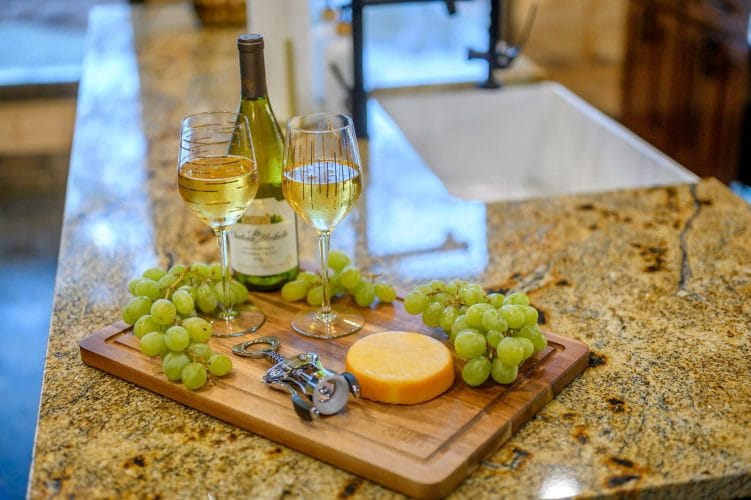 Wine glass and green grapes on a wooden board