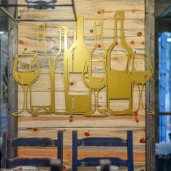 Gold metal wine glass and bottle wall art on wood