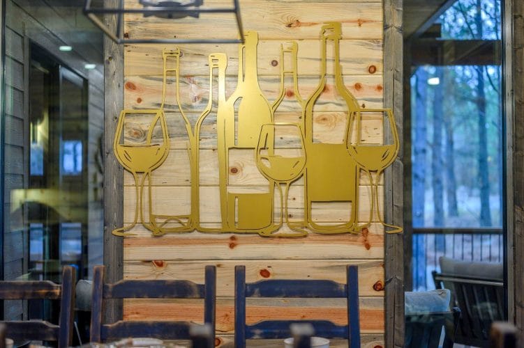Gold metal wine glass and bottle wall art on wood
