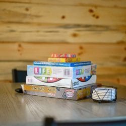 Stack of board games including Life, Uno and Skip-Bo