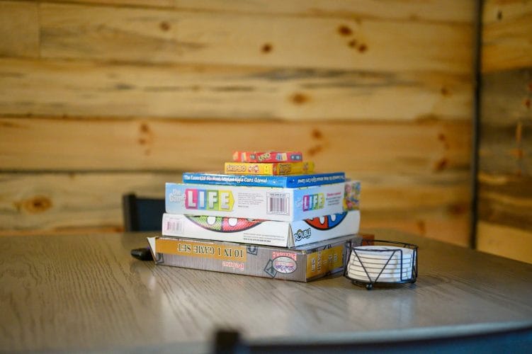 Stack of board games including Life, Uno and Skip-Bo