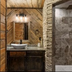 Vanity with a vessel sink beside a tiled walk-in shower
