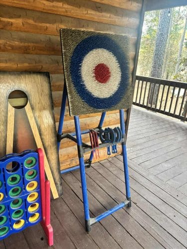 Ring-toss target with horseshoes hanging on its stand on the deck