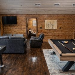 Game loft with a black-felt pool table, air hockey, a sofa and a TV