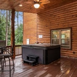 Hot tub on the deck beside a bar-height table and chairs