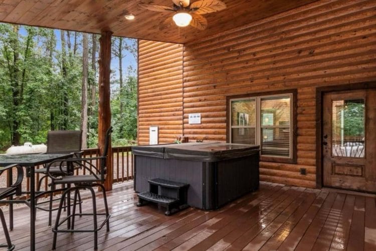 Hot tub on the deck beside a bar-height table and chairs
