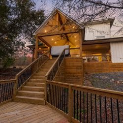 Cabin seen from the deck stairs at dusk, with the covered deck lit up