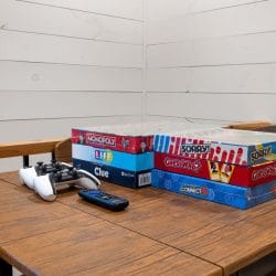 Board games and game controllers on a wooden table in the loft