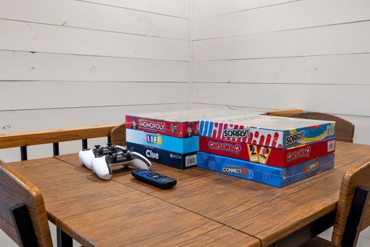 Board games and game controllers on a wooden table in the loft