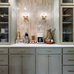 Coffee bar with glass-front cabinets, brass wall lights and a tile backsplash