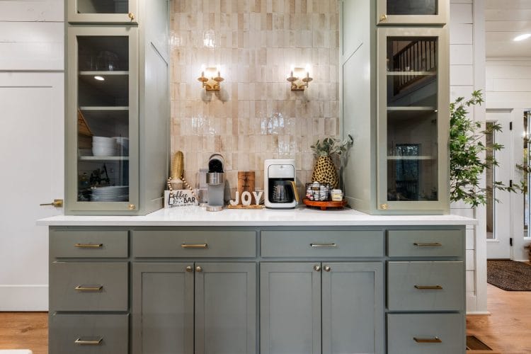 Coffee bar with glass-front cabinets, brass wall lights and a tile backsplash