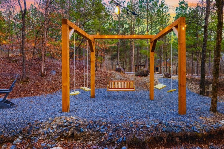 Timber swing frame with bench swings on a gravel pad