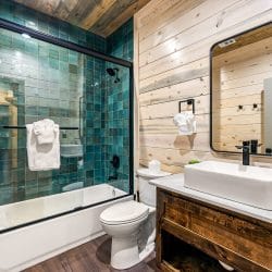 Guest bathroom with a vessel sink and a teal tile tub-shower