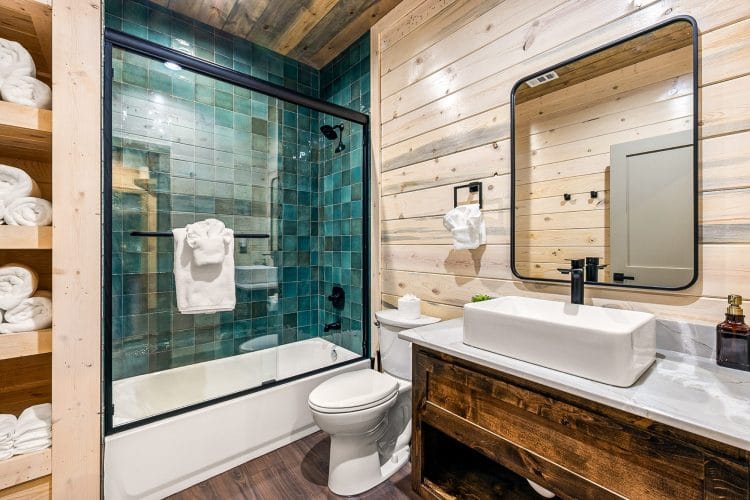 Guest bathroom with a vessel sink and a teal tile tub-shower