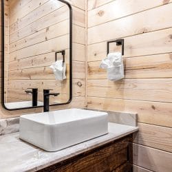 Half bath with a vessel sink and a black faucet